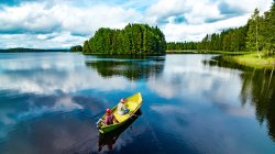 stiller See in Finnland und Kajakfahrer. 