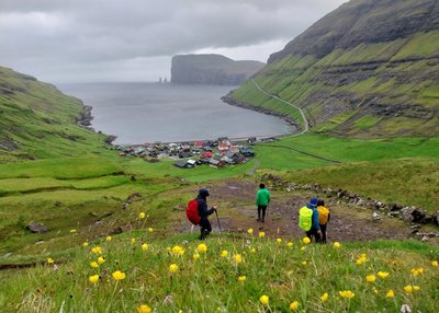 Eine Wandergruppe steigt hinunter nach Tjornuvik auf den Färöer-Inseln