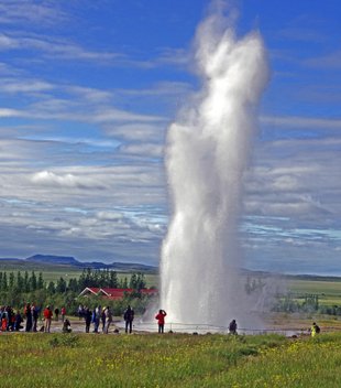 Island Urlaub als Gruppenreise - Touristen in Geysir stehen um die Springquelle Strokkur