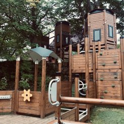 Ein Klettergerüst aus Holz auf einem Spielplatz.