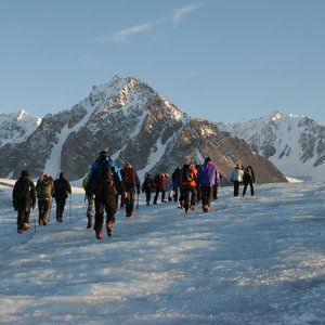 Eine Gruppe Menschen läuft über eine vereiste Fläche in Spitzbergen