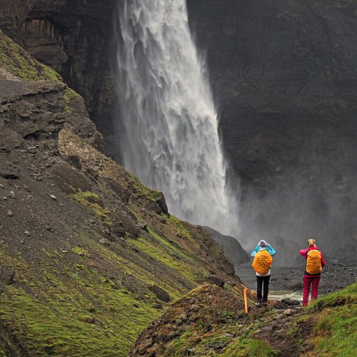 Zwei Wanderer an einem Wasserfall