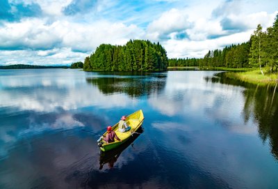 stiller See in Finnland und Kajakfahrer. 