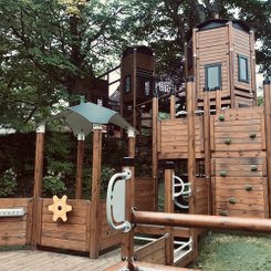 Ein Klettergerüst aus Holz auf einem Spielplatz.