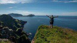 Wanderer auf einem Felsvorsprung in Runde Norwegen