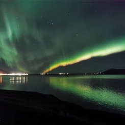 Polarlichter die sich über einen Fjord erstrecken