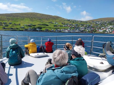 die kleine Reisegruppe genießt den Ausblick auf die Färöer Inseln vom Boot aus