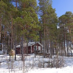 Hütte auf verschneiter einsamer Insel in Schwedisch-Lappland