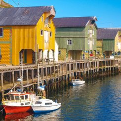 kleine Boote in einem Hafen mit bunten Häusern.