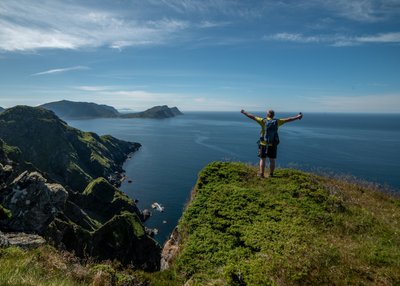Wanderer auf einem Felsvorsprung in Runde Norwegen