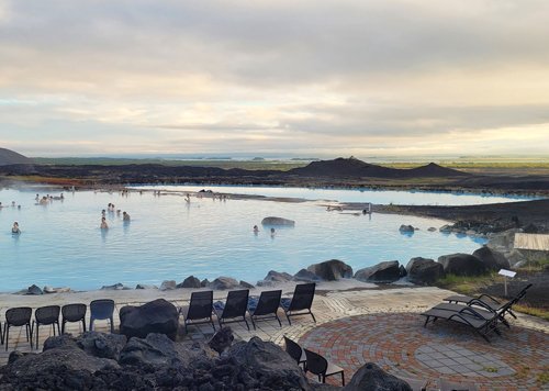 Geothermalbad am Myvatn mit Liegen und der Lavalandschaft im Hintergrund