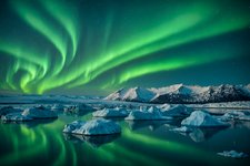 Grünlich tanzende Polarlichter über der Gletscherlagune im Südosten Islands