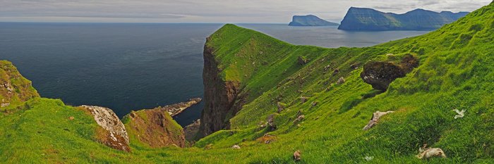 Typisch für Färöer Reisen - Zerklüftete, grüne Steilküste mit auf den Nordatlantik
