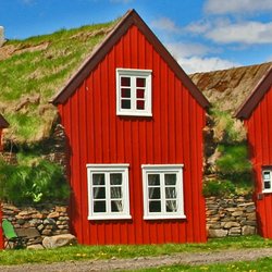 Urige Unterkunft auf Reisen durch Island - Historisches Torfhaus mit Holzfassade und Grasdach