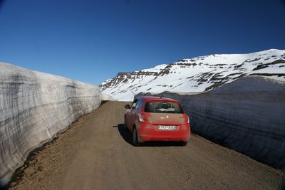 Island Rundreise im Frühjahr Im isländischen Frühling auf einer Autorundreise - Eine Passstraße mit Schneewänden in den Ostfjorden
