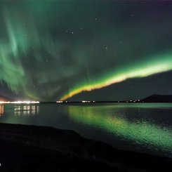 Polarlichter die sich über einen Fjord erstrecken