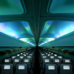 Flüge für Island Reisen - Innenraum eines Passagierflugzeugs mit blaugrünlicher Nordlicht-Beleuchtung