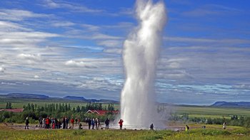 Auch für Gruppen bietet Island tolle Reisen - Wasserfontäne des Geysirs Strokkur mit Besuchergruppe
